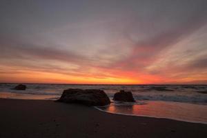 hermoso paisaje marino al amanecer, colorido cielo rosa y naranja y tormenta en el mar. foto