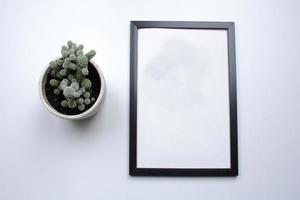 top view of photoframe on white table with plant decoration photo