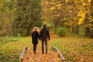 couple of tourist walking having good time in autumn park photo