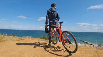 Young male on the bicycle with helmet ride on the beach photo