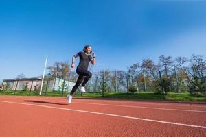 Young female runner training in summer day outdoors on the studium photo