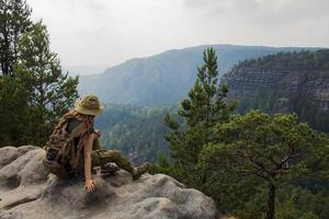 Young woman hiking on the spring meadow, mountains and forest on background photo