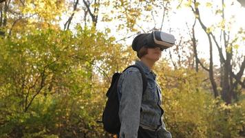 Happy Young Female With Virtual Reality Glasses having fun in autumn park photo