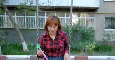 giovane donna gioca con le bolle di sapone all'aperto video