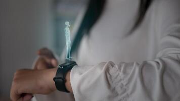 kvinnlig hand med futuristisk smartklocka interagerar med ett hud-hologram. kvinna använder framtidens holografiska teknologi på ett armbandsur. medicinsk och livsstilskoncept. video