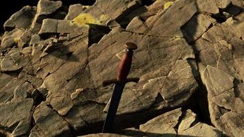 Excalibur sword in rocky stone at sunset video