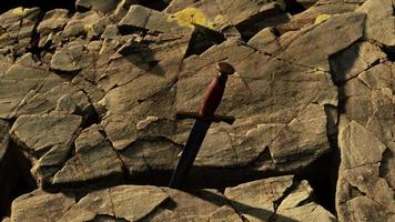 Excalibur sword in rocky stone at sunset video