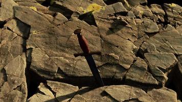 Excalibur sword in rocky stone at sunset video