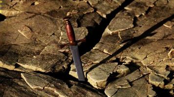 excalibur zwaard in rotsachtige steen bij zonsondergang