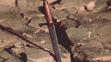 excalibur zwaard in rotsachtige steen bij zonsondergang