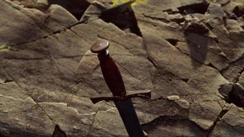 Excalibur sword in rocky stone at sunset video