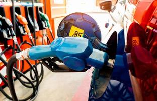 Car fueling at gas station. Refuel fill up with petrol gasoline. Petrol pump filling fuel nozzle in fuel tank of car at gas station. Petrol industry and service. Petrol price and oil crisis concept. photo