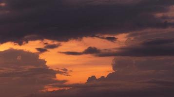 hermoso cielo naranja de puesta de sol con capas de nubes grises y oscuras. vista panorámica. belleza en la naturaleza. cielo crepuscular cielo del cielo al atardecer para un fondo tranquilo y pacífico. cielo romántico al atardecer. foto