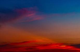 Dramático cielo rojo y azul y fondo abstracto de nubes. nubes rojo-azules en el cielo del atardecer. fondo de clima cálido. imagen artística del cielo al atardecer. fondo abstracto al atardecer. triste y dramático cielo de puesta de sol. foto