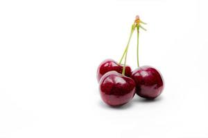 Red cherry with stalk isolated on white background. Ripe red sweet cherry. Sweet and juicy organic cherry. Fresh fruit for summer dessert. Antioxidant food. Healthy snack. photo