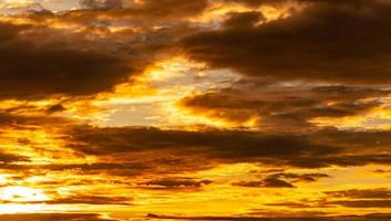 Beautiful sunset sky. Golden sunset sky with beautiful pattern of clouds. Orange, yellow, and dark clouds in the evening. Freedom and calm background. Beauty in nature. Powerful and spiritual scene. photo