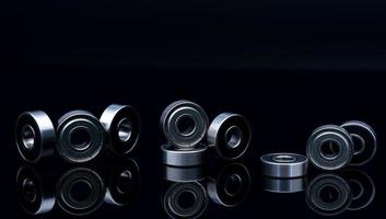 Stainless steel ball bearing on blackk background. Set of thrust ball bearing and silver ball bearing. Spare parts for roller machine in heavy machinery and automotive industry. Round metal wheel. photo