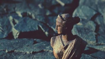 antigua estatua de mujer en piedras rocosas