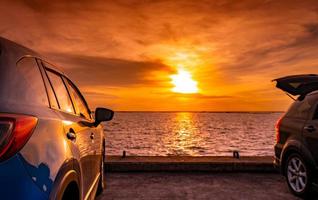 camión suv negro y azul con diseño deportivo y moderno estacionado en una carretera de hormigón junto al mar al atardecer. tecnología respetuosa con el medio ambiente. viaje por carretera viaje de vacaciones en la playa y camión abierto foto