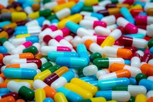 Selective focus on multi-colored antibiotic capsule pills. Antibiotic drug resistance concept. Pile of colorful capsule pills. Pharmaceutical industry. Antimicrobial drug for treatment infection.
