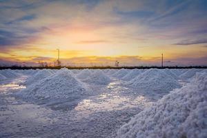 Salt farm in the morning with sunrise sky. Organic sea salt. Evaporation and crystallization of sea water. Raw material of salt industrial. Sodium Chloride. Solar evaporation system. Iodine salt.