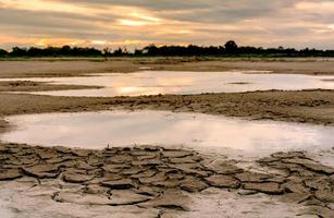 Climate change and drought land. Water crisis. Arid climate. Crack soil. Global warming. Environment problem. Nature disaster. Dry soil texture background. Nature lanscape in the morning with sunrise. photo