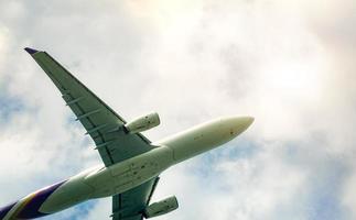 aerolínea comercial volando sobre cielo azul y nubes blancas esponjosas. bajo la vista del vuelo del avión. avión de pasajeros después de despegar o ir al vuelo de aterrizaje. viajes de vacaciones al extranjero. transporte aéreo. foto