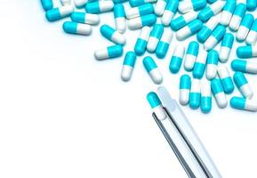 Forceps pick white-blue capsule from group of capsule pills. Drugs choose. Antibiotic drug selection. Antibiotic drug resistance concept. QA and QC in pharmaceutical factory concept. Drugs of choice. photo