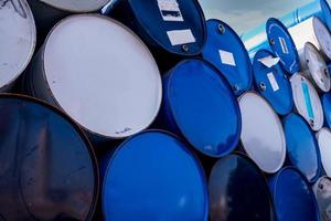 Closeup old chemical barrels. Blue and white oil drum. Steel oil tank. Toxic waste warehouse. Hazard chemical barrel. Industrial waste in old drum. Hazard waste storage in factory. Metal barrels. photo