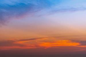 Dramático cielo azul y naranja y fondo abstracto de nubes. nubes de color rojo anaranjado en el cielo del atardecer. fondo de clima cálido. imagen artística del cielo al atardecer. fondo abstracto al atardecer. concepto de anochecer y amanecer foto