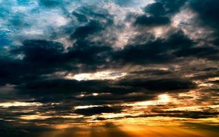God light. Dramatic dark cloudy sky with sun beam. Yellow sun rays through dark and gray clouds. God light from heaven for hope and faithful concept. Believe in god. Beautiful sunlight sky background photo