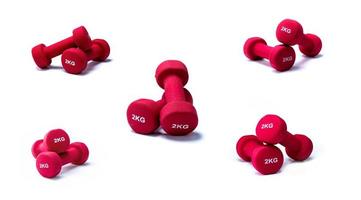 Set of red dumbbells isolated on white background. A pair of red neoprene dumbbells. Home gym equipment for exercise at home. Weight training equipment. Small dumbbells for muscle strength building photo