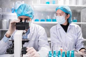 scientist looking through scientific microscope lense in laboratory, scientist doing research in term of medicine biotechnology biology or chemistry, doctor analyzing work in medical microbiology lab photo