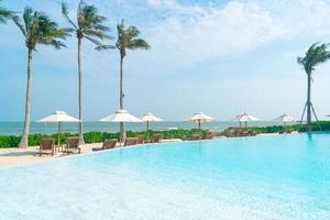 umbrella with bed pool around swimming pool with ocean sea background photo