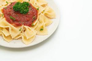 pasta farfalle en salsa de tomate con perejil foto