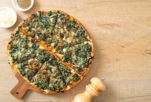 spinach and cheese pizza on wood tray