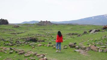 Caucasian female tourist walk around Ani ruins sightseeing in spring. Travel destination in Kars video