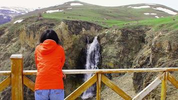 Young caucasian woman stand on viewpoint enjoy Susuz waterfall panorama outdoors on holiday video