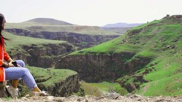 Female tourist enjoy sunny windy day in Ani archeological site watch valley. Armenia Turkey border line. video