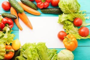 Frame of vegetables with white copy space on blue wooden table. Top view photo