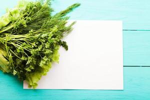 Parsley and recipe paper on blue wooden kitchen table. Top view photo
