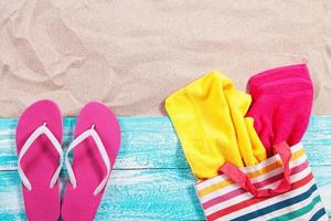 Sand copy space. Sand background top view. Beach towels in a beach bag and beach slippers photo