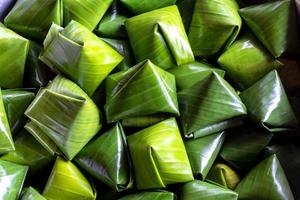Dessert wrapped in banana leaves triangular. photo