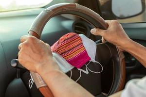 Many face masks are placed in the car with hands. photo