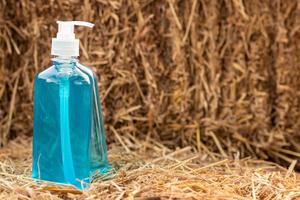 Blue bottle of gel with a pile of straw. photo