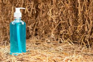 Blue bottle of gel with a pile of straw. photo