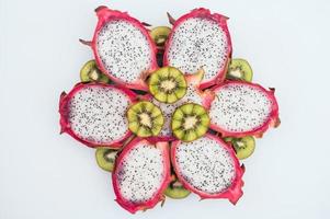 concepto de arte culinario. rodajas de kiwi verde y fruta de dragón formadas en forma de flor. fruta exótica fresca y saludable sobre fondo blanco. alimentación saludable y vitaminas.