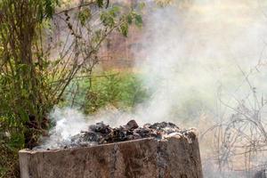 viejos tanques de concreto queman desechos, provocando humo. foto