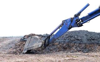 Backhoe blue spade laying on the ground, road debris. photo
