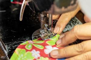 A close up, sewing the fabric on the old machine. photo